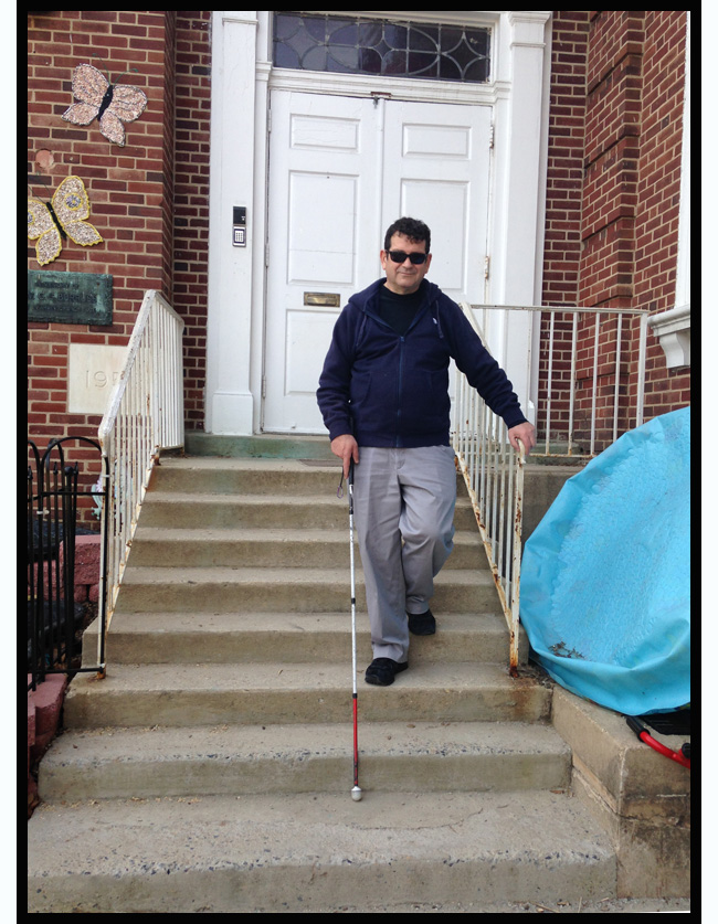 two photos show Randy coming down a flight of concrete steps with his right hand on the end of the railing and left hand holding his white cane.  He has one foot on the third step from the bottom and is extending his other foot to the next stair.